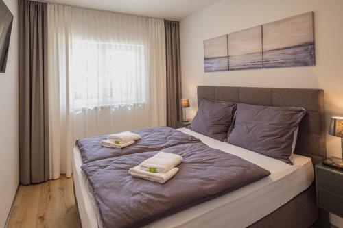 ein Schlafzimmer mit einem Bett mit zwei Handtüchern darauf in der Unterkunft Deluxe Apartment Graz in Graz