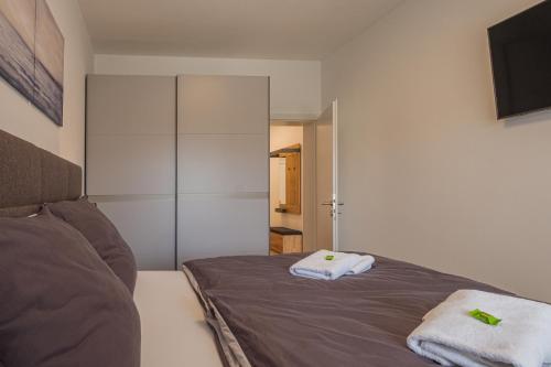 ein Schlafzimmer mit einem Bett mit zwei Handtüchern darauf in der Unterkunft Deluxe Apartment Graz in Graz