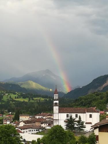 a rainbow over a town with a building with a tower at Mini appartamento panoramico in Sùtrio