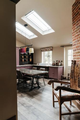 a kitchen with a table and chairs in a room at The Shepherds Huts & The Well Lodge at Ormesby Manor in Ormesby Saint Michael