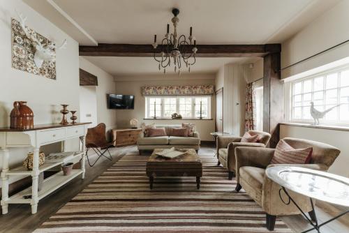a living room filled with furniture and a chandelier at The Shepherds Huts & The Well Lodge at Ormesby Manor in Ormesby Saint Michael