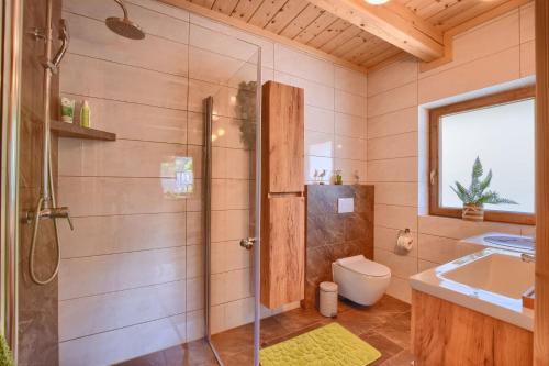 a bathroom with a shower and a toilet and a sink at Domki inNatura in Istebna