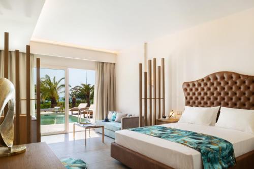 een slaapkamer met een bed en een woonkamer bij Alexandra Beach Spa Resort in Potos