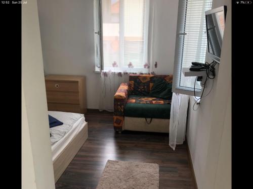 a living room with a couch and a window at Къща за гости “Family” in Varshets