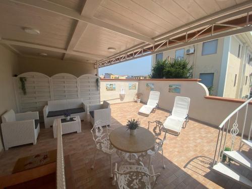 a patio with a table and chairs and a couch at La casa di Vesta in Pompei