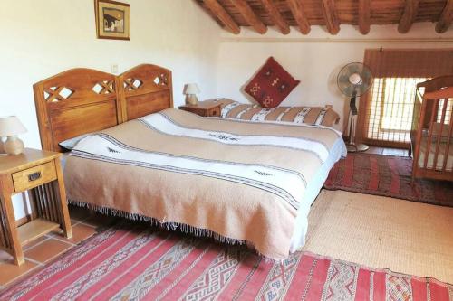 Un dormitorio con 2 camas y una mesa con ventilador. en Fincaretama Farmhouse Apartment Ronda, en Ronda