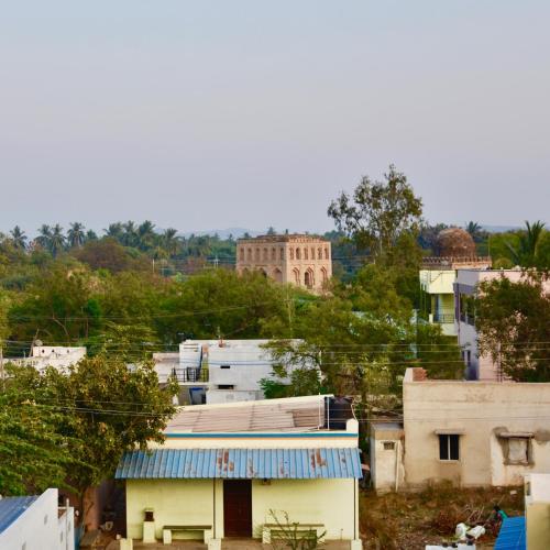 a group of buildings with a building in the background at Jasmin Villa in Hampi