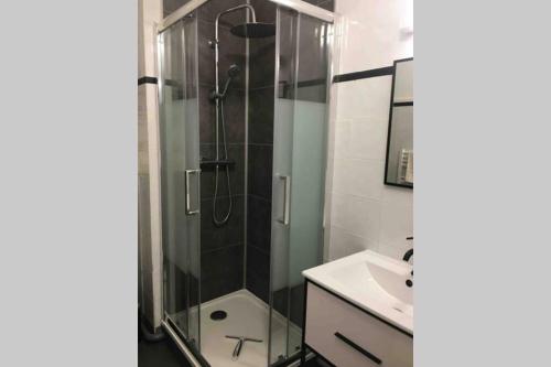 une salle de bain avec une douche en verre et un lavabo dans l'établissement Au Cœur du Marché, à Boulogne-sur-Mer