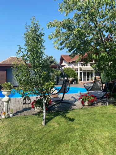 a garden with a tree and a swimming pool at Leisure House Hunedoara in Uroi
