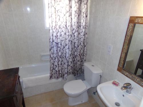 e bagno con servizi igienici, lavandino e tenda per la doccia. di Cyking Apartment 103 postcode 8046 a Paphos