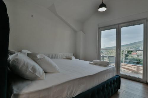 a bedroom with a large bed with a large window at Villa TEMA in Ohrid