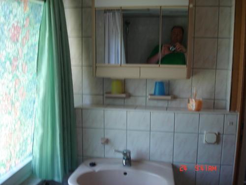SüplingenにあるFerienhaus Süplingenの浴室鏡で写真を撮る男
