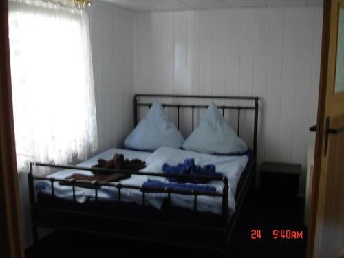 a bed with pillows and towels on it with a window at Ferienhaus Süplingen in Süplingen