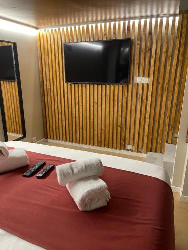 une chambre d'hôtel avec des serviettes sur un lit et une télévision dans l'établissement Suite souplex Païka, à Montpellier