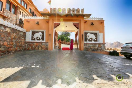 a woman in a red dress standing outside of a building at Fateh Garh Resort by Fateh Collection in Udaipur