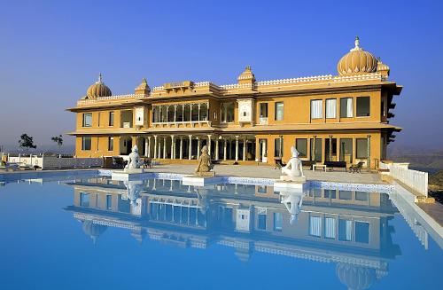 a large building with a pool of water in front of it at Fateh Garh Resort by Fateh Collection in Udaipur
