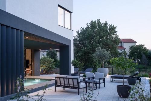 a patio with chairs and a swimming pool next to a house at Koralle Mugeba in Mugeba