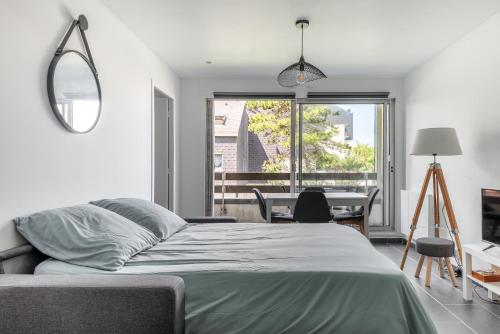 濱海庫爾瑟萊的住宿－Appt lumineux - Avec balcon à 400m de la plage，一间卧室配有一张床、一张桌子和一个窗户。