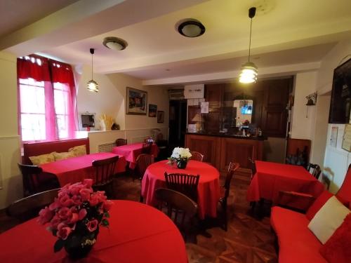 a restaurant with red tables and chairs with flowers on them at Hotel de Savoie in Annecy