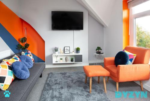 a living room with orange chairs and a tv at River View - 1 Bed Serviced Apartment in Cardiff City Center - Street Parking - By DYZYN in Cardiff