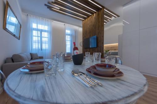 a table with plates and glasses on it in a living room at 1571_SUITES A1 in Nafpaktos