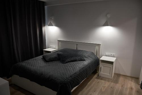 1 dormitorio con 1 cama y 2 mesitas de noche en Rundale Solstice Apartment, en Pilsrundāle