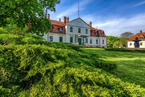 a large white house with a red roof at Kadyny Folwark Hotel & SPA in Kadyny