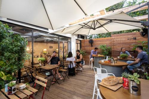 a group of people sitting at tables on a patio at Hotel 75 by Prima Hotels in Tel Aviv