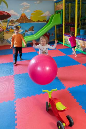 a little girl playing with a ball in a play room at Hotel Columbia in Marina Romea