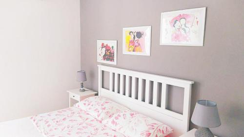 1 dormitorio con cuna blanca y cuadros en la pared en Spiaggetta, en Lido Marini