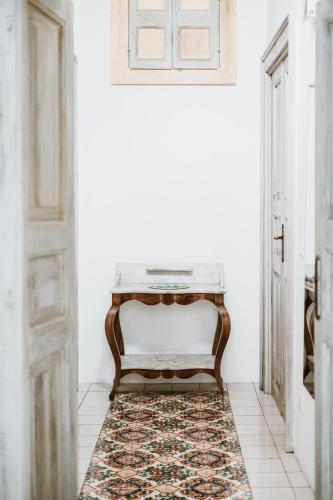 a console table in a hallway with a rug at Boutique Hotel I Cinque Balconi in Santa Marina Salina