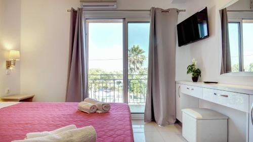 een slaapkamer met een bed en een groot raam bij Makis louvlis apartments in Moraitika