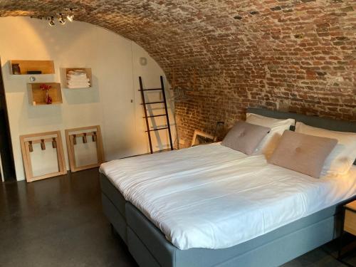 a bedroom with a bed in a brick wall at De Hoendervorst in Utrecht