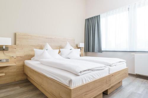 a bedroom with a large bed with white sheets at Hotel Forsthaus Grüna Betreibergesellschaft mbH in Chemnitz