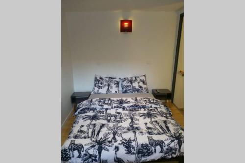 une chambre avec un lit avec une couette noire et blanche dans l'établissement Petite maisonnette d'environ 25m2 tout confort, à Oraison