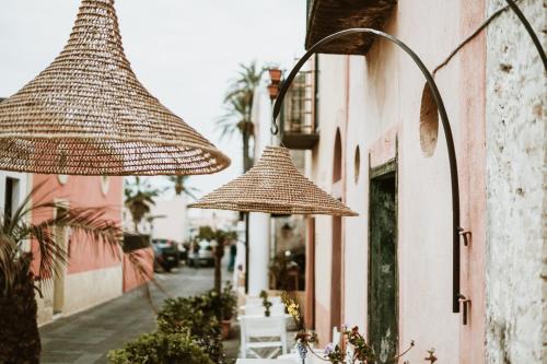 deux parapluies suspendus sur le côté d'un bâtiment dans l'établissement Hotel I Cinque Balconi, à Santa Marina Salina