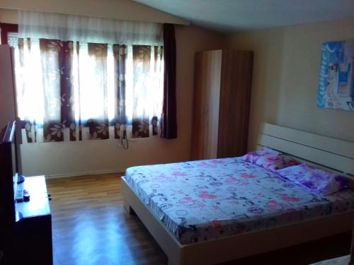 a bedroom with a bed and two windows at Marko Apartments in Struga