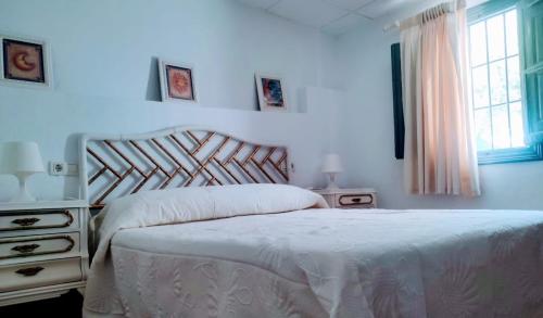 een witte slaapkamer met een bed en een raam bij Benal Country Old House in Benalmádena