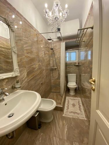un bagno con lavandino, servizi igienici e lampadario pendente di Studio Apartment Naya a Mali Lošinj (Lussinpiccolo)