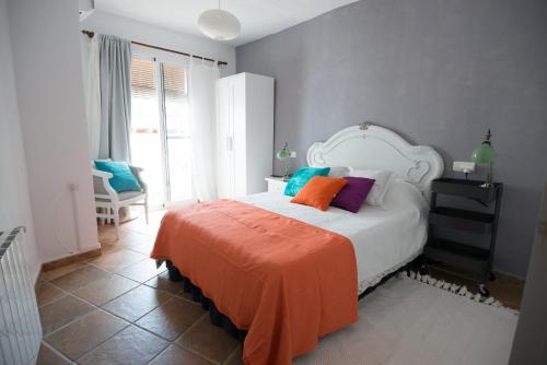 - une chambre avec un lit et une couverture orange dans l'établissement Casa Turquesa 25 Minuten vom Strand, à Guájar Fondón