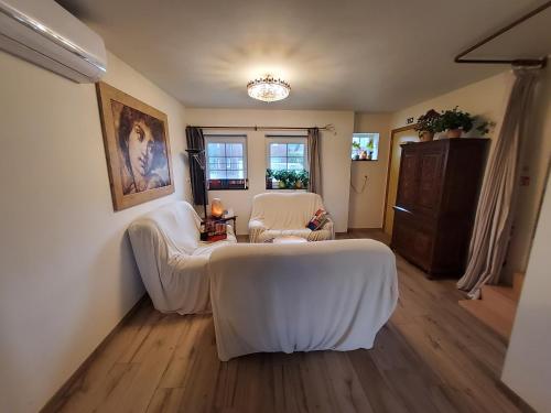 a living room with two white chairs and a table at Holiday Home IRENE in Lilo