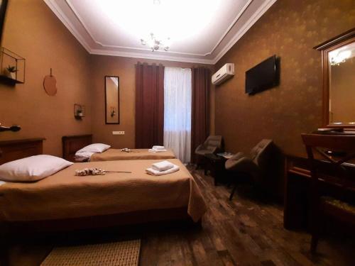 una camera d'albergo con 2 letti e una scrivania di Bogdanov Yar Hotel a Kiev