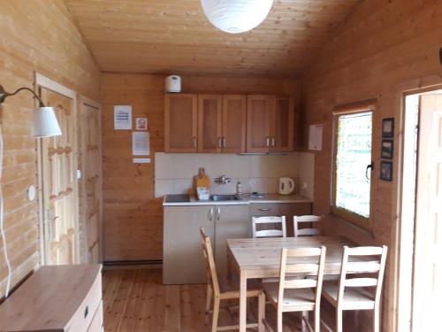 a kitchen with a table and chairs in a cabin at Domek letniskowy Barakuda in Chałupy