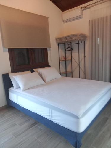 a bed with white sheets and pillows in a room at Elli S onar in Sykia Chalkidikis
