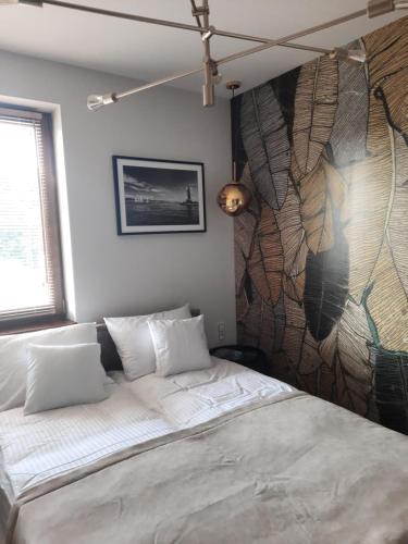 a bedroom with a bed and a wall with a mural at Apartament Latarnik- STANDARD in Gąski