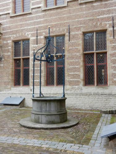 a fountain in front of a brick building at Kom tot rust in The Forest in Putte