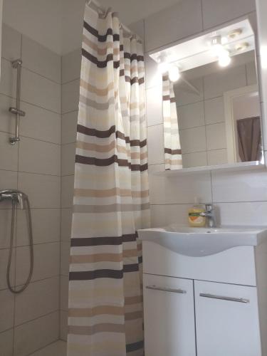 a bathroom with a shower curtain and a sink at San Eleuterio Guesthouse in Poreč