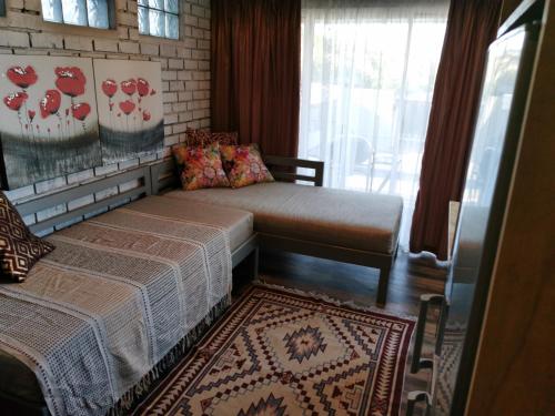 a bedroom with two beds and a window and a rug at Tranquility in Parow