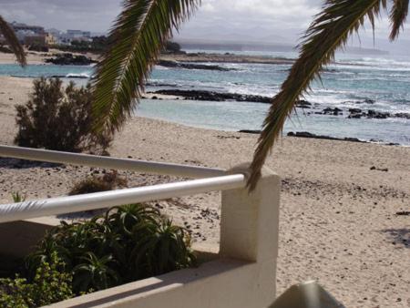 a view of the beach from the balcony of a house at Maravilla Bungalows in Cotillo