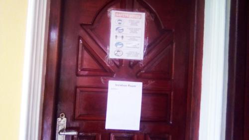 a brown door with signs on it at Grace Villa Bentota in Bentota